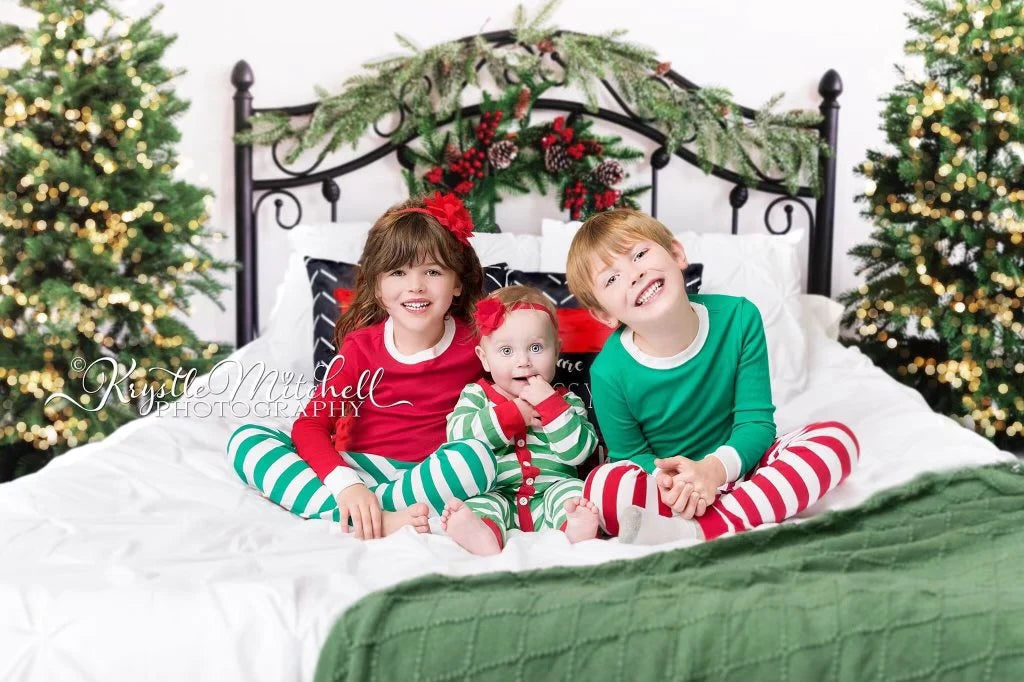 Drei Kinder spielen zu Hause auf dem Weihnachtsbett