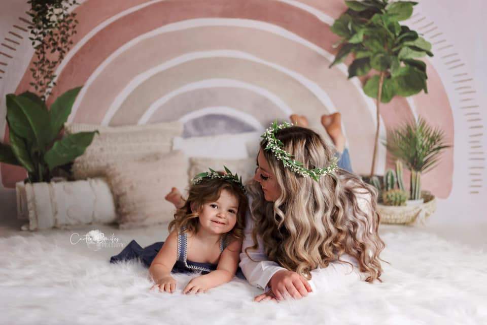 Mutter und Tochter liegen auf dem Regenbogenbett