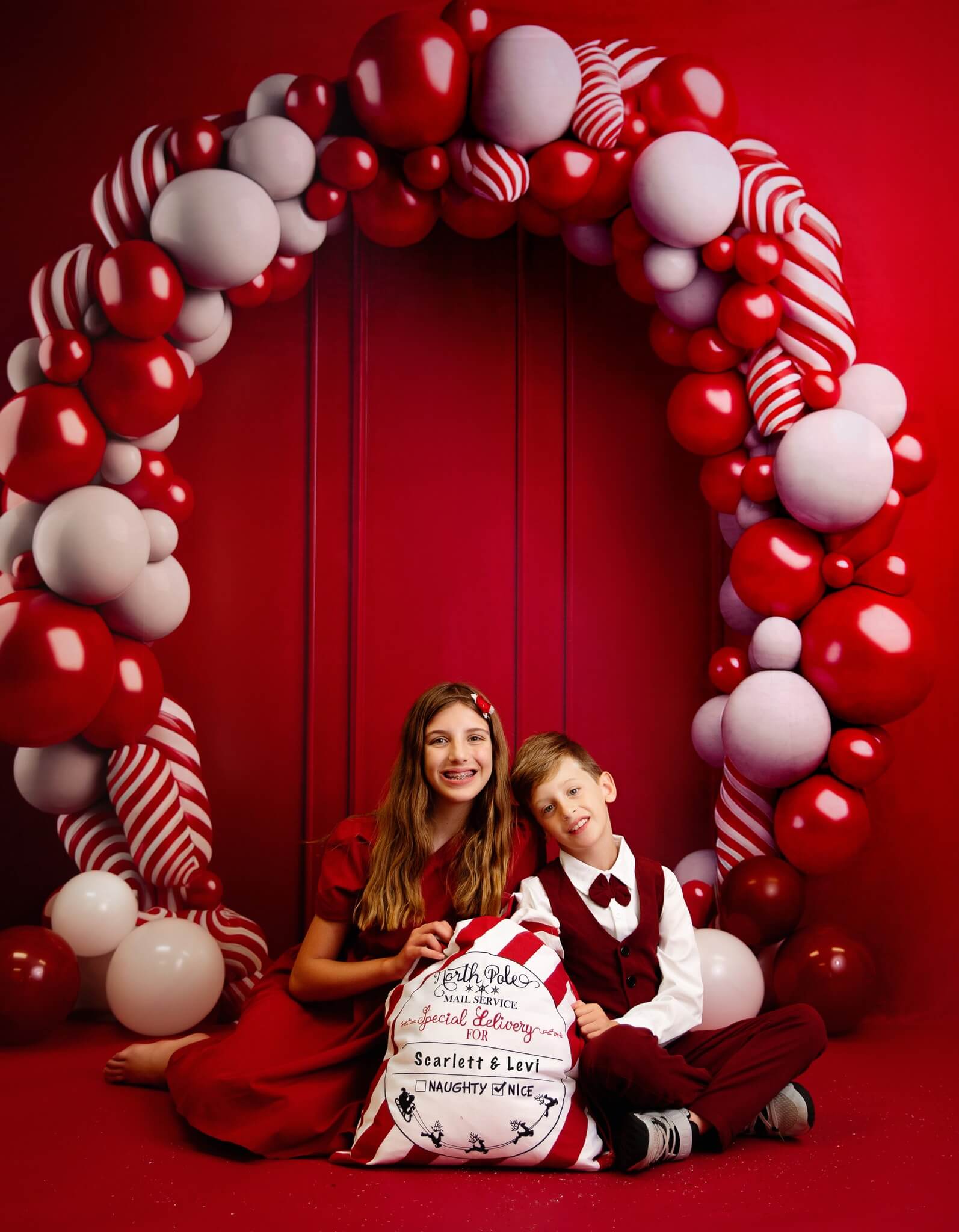 Kate Zuckerstangen Luftballons Bogen Rote Wand Hintergrund von Megan Leigh Photography